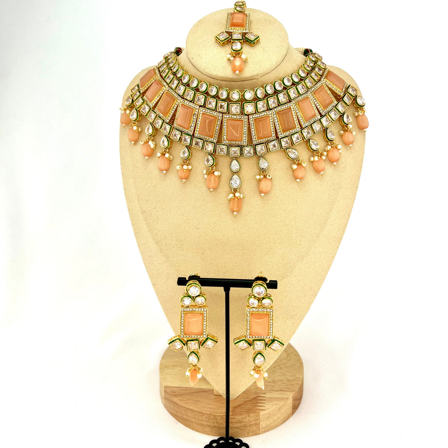 Necklace set with peach and clear stones and peach beads. Set includes necklace, tikka and earrings. Prefect for Indian weddings, parties and special occasions. Latest 2022 fashion. High end Indian fashion jewellery with top quality stones and beads.