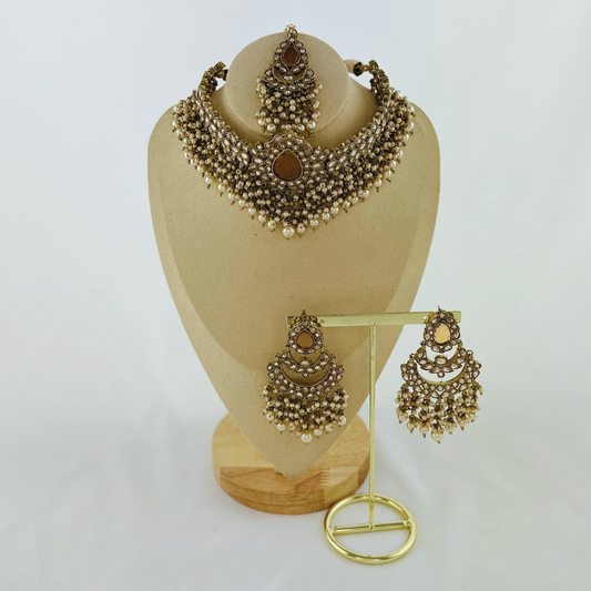 Choker set with bronze stones and white pearl beads. Set includes necklace, tikka & earrings. Prefect for Indian weddings, parties and special occasions. Latest 2023 fashion. High end Indian fashion jewellery with top quality stones and beads.
