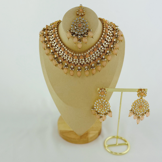Necklace set with peach stones and beads. Set includes necklace, tikka & earrings. Prefect for Indian weddings, parties and special occasions. Latest 2023 fashion. High end Indian fashion jewellery with top quality stones and beads.