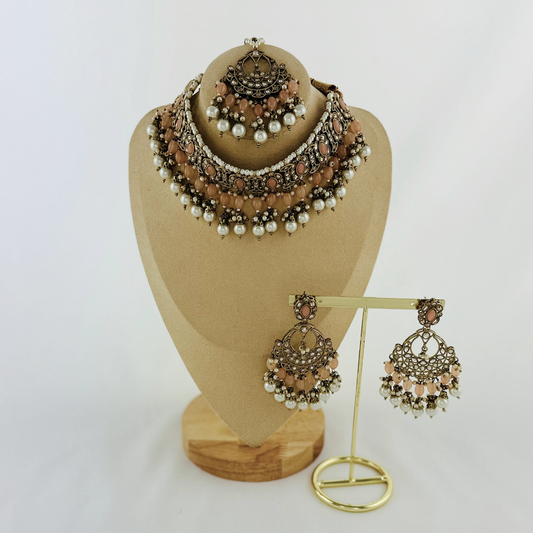 Necklace set with peach stones and white pearl beads. Set includes necklace, tikka & earrings. Prefect for Indian weddings, parties and special occasions. Latest 2023 fashion. High end Indian fashion jewellery with top quality stones and beads.