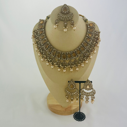 Necklace set with bronze stones and white pearl beads. Set includes necklace, tikka & earrings. Prefect for Indian weddings, parties and special occasions. Latest 2023 fashion. High end Indian fashion jewellery with top quality stones and beads.