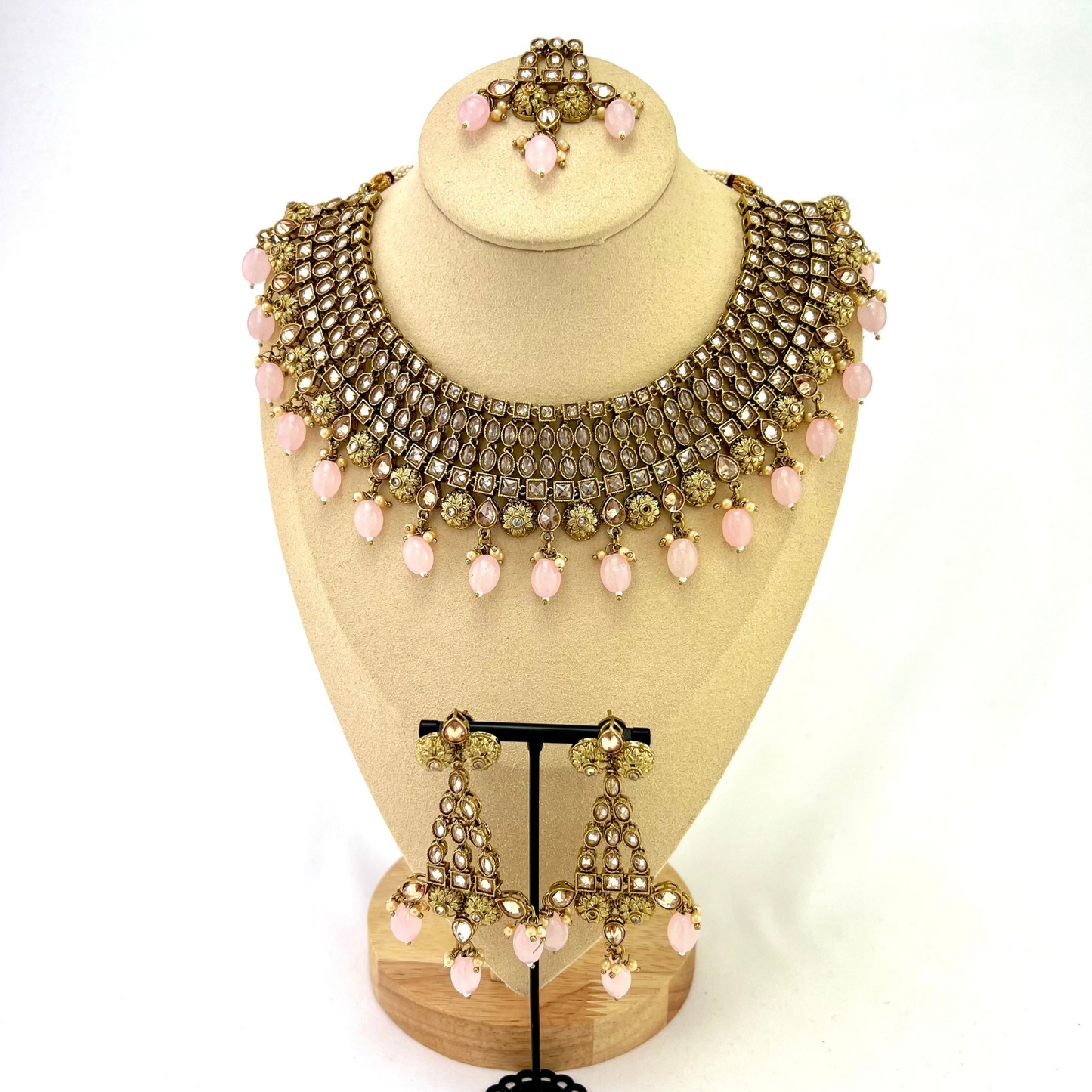 Necklace set with pink beads and gold stone work. Set includes necklace, tikka and earrings. Prefect for Indian weddings, parties and special occasions. Latest 2022 fashion. High end Indian fashion jewellery with top quality stones and beads.