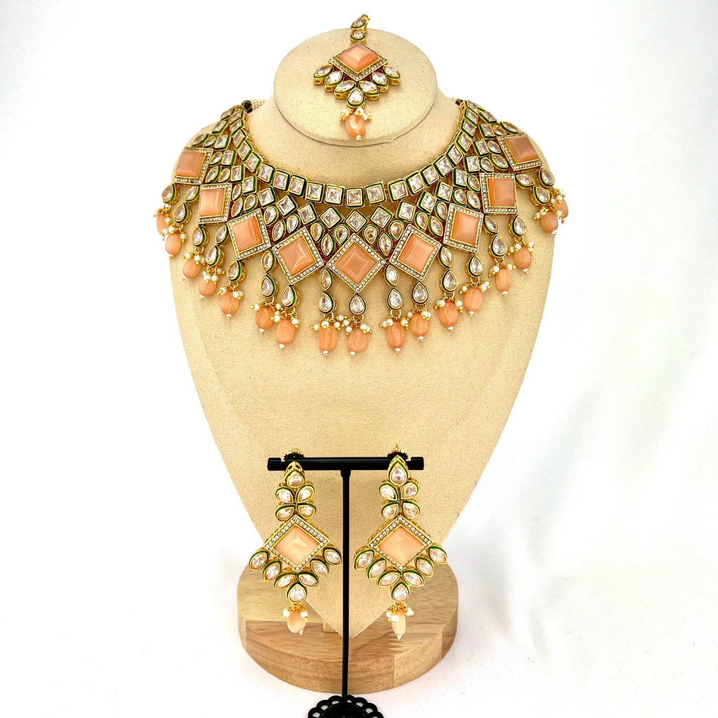 Necklace set with peach beads and peach and clear stone. Set includes necklace, tikka & earrings. Prefect for Indian weddings, parties and special occasions. Latest 2022 fashion. High end Indian fashion jewellery with top quality stones and beads.
