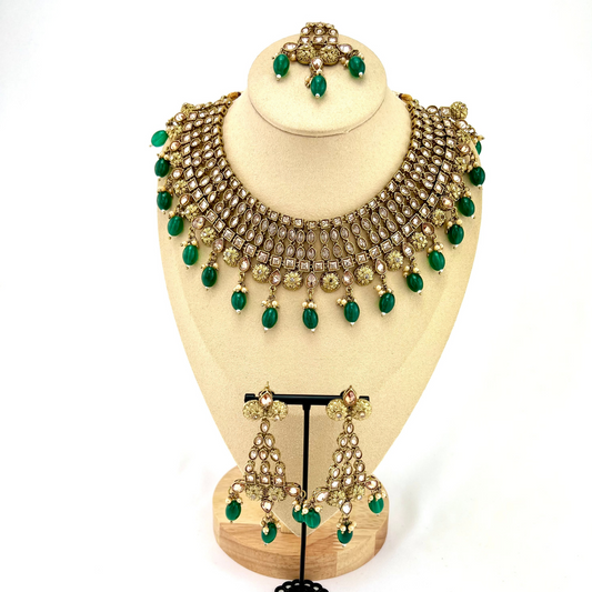 Necklace set with green beads and gold stone work. Set includes necklace, tikka and earrings. Prefect for Indian weddings, parties and special occasions. Latest 2022 fashion. High end Indian fashion jewellery with top quality stones and beads.