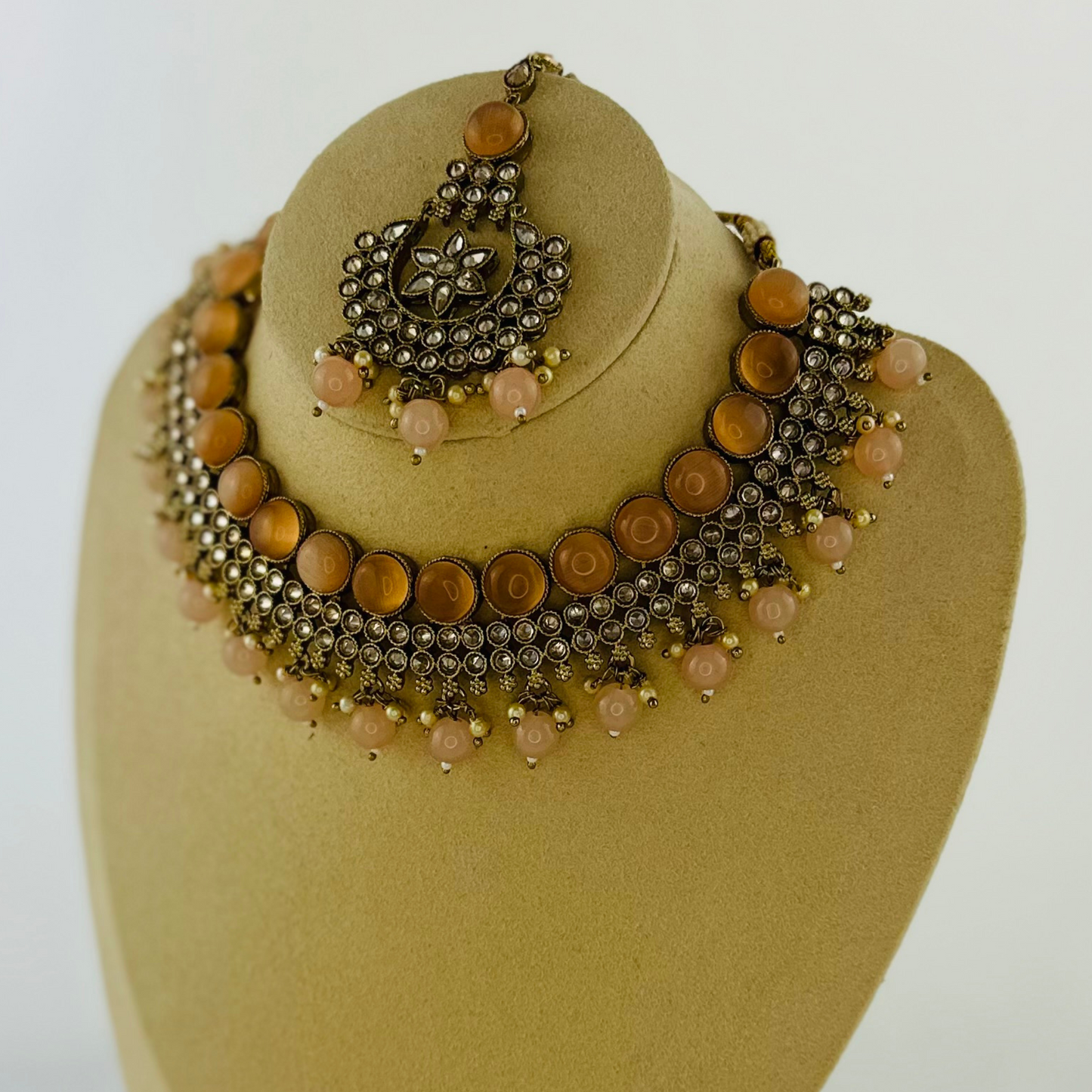 Necklace set with peach stones and beads. Set includes necklace, tikka & earrings. Prefect for Indian weddings, parties and special occasions. Latest 2023 fashion. High end Indian fashion jewellery with top quality stones and beads.