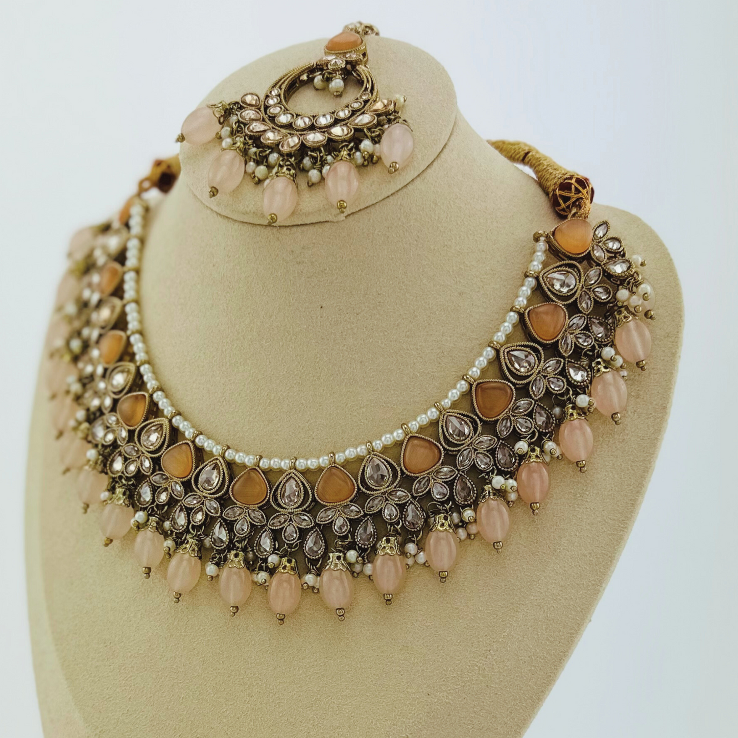 Necklace set with peach stones and beads. Set includes necklace, tikka & earrings. Prefect for Indian weddings, parties and special occasions. Latest 2023 fashion. High end Indian fashion jewellery with top quality stones and beads.