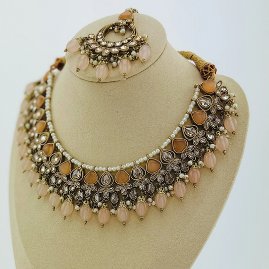 Necklace set with peach stones and beads. Set includes necklace, tikka & earrings. Prefect for Indian weddings, parties and special occasions. Latest 2023 fashion. High end Indian fashion jewellery with top quality stones and beads.