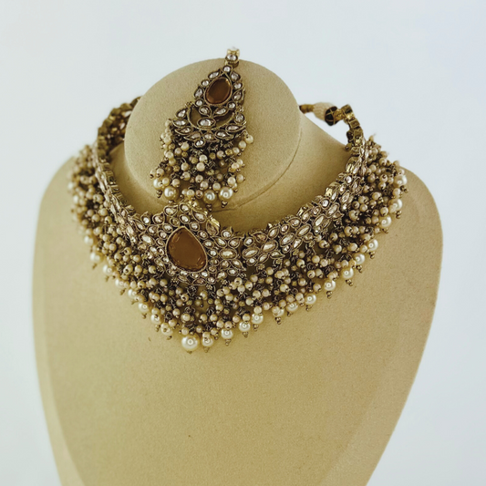 Choker set with bronze stones and white pearl beads. Set includes necklace, tikka & earrings. Prefect for Indian weddings, parties and special occasions. Latest 2023 fashion. High end Indian fashion jewellery with top quality stones and beads.