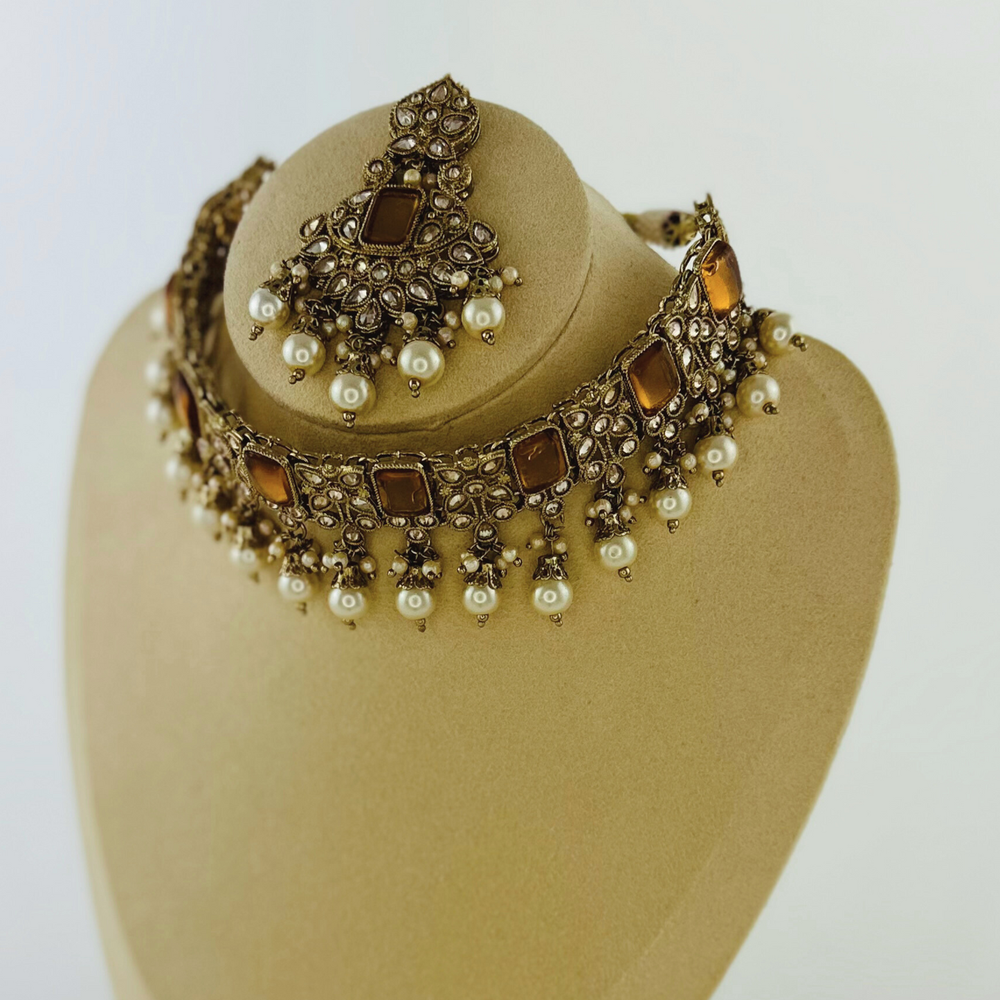 Choker set with white bead and bronze stones. Set includes necklace, tikka & earrings. Prefect for Indian weddings, parties and special occasions. Latest 2023 fashion. High end Indian fashion jewellery with top quality stones and beads.