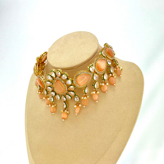 Choker set with peach, clear stones and peach beads. Set includes choker, tikka and earrings. Prefect for Indian weddings, parties and special occasions. Latest 2022 fashion. High end Indian fashion jewellery with top quality stones and beads.
