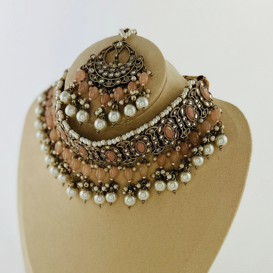 Necklace set with peach stones and white pearl beads. Set includes necklace, tikka & earrings. Prefect for Indian weddings, parties and special occasions. Latest 2023 fashion. High end Indian fashion jewellery with top quality stones and beads.