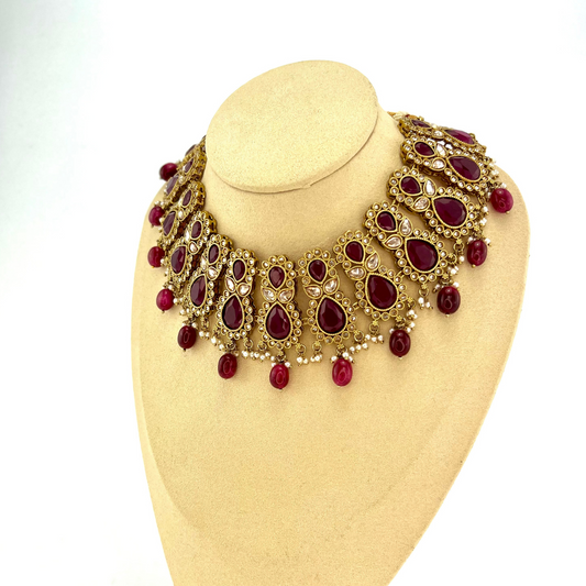 Necklace set with maroon and gold stone work and maroon beads. Set includes necklace, tikka and earrings. Prefect for Indian weddings, parties and special occasions. Latest 2022 fashion. High end Indian fashion jewellery with top quality stones and beads.