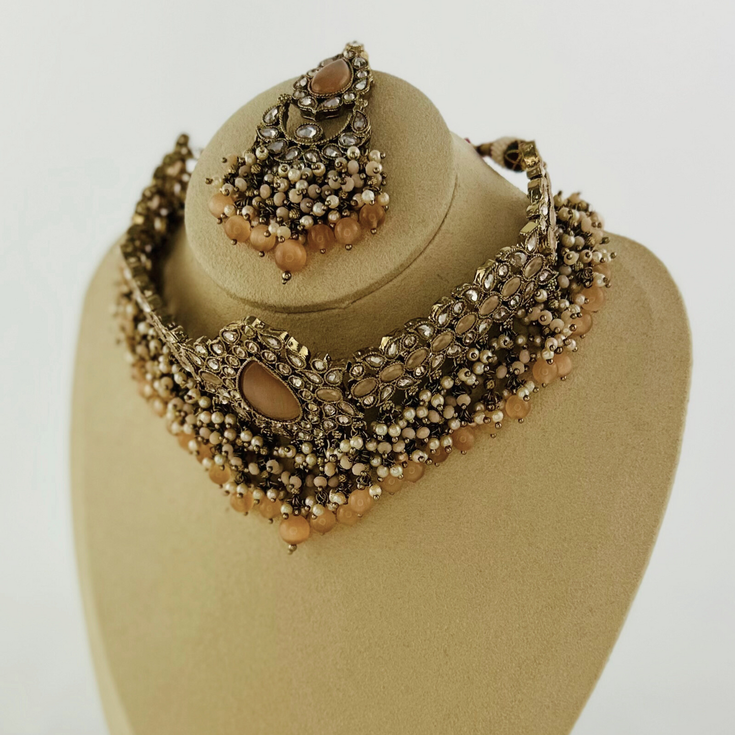 Choker set with peach beads and stones. Set includes necklace, tikka & earrings. Prefect for Indian weddings, parties and special occasions. Latest 2023 fashion. High end Indian fashion jewellery with top quality stones and beads.