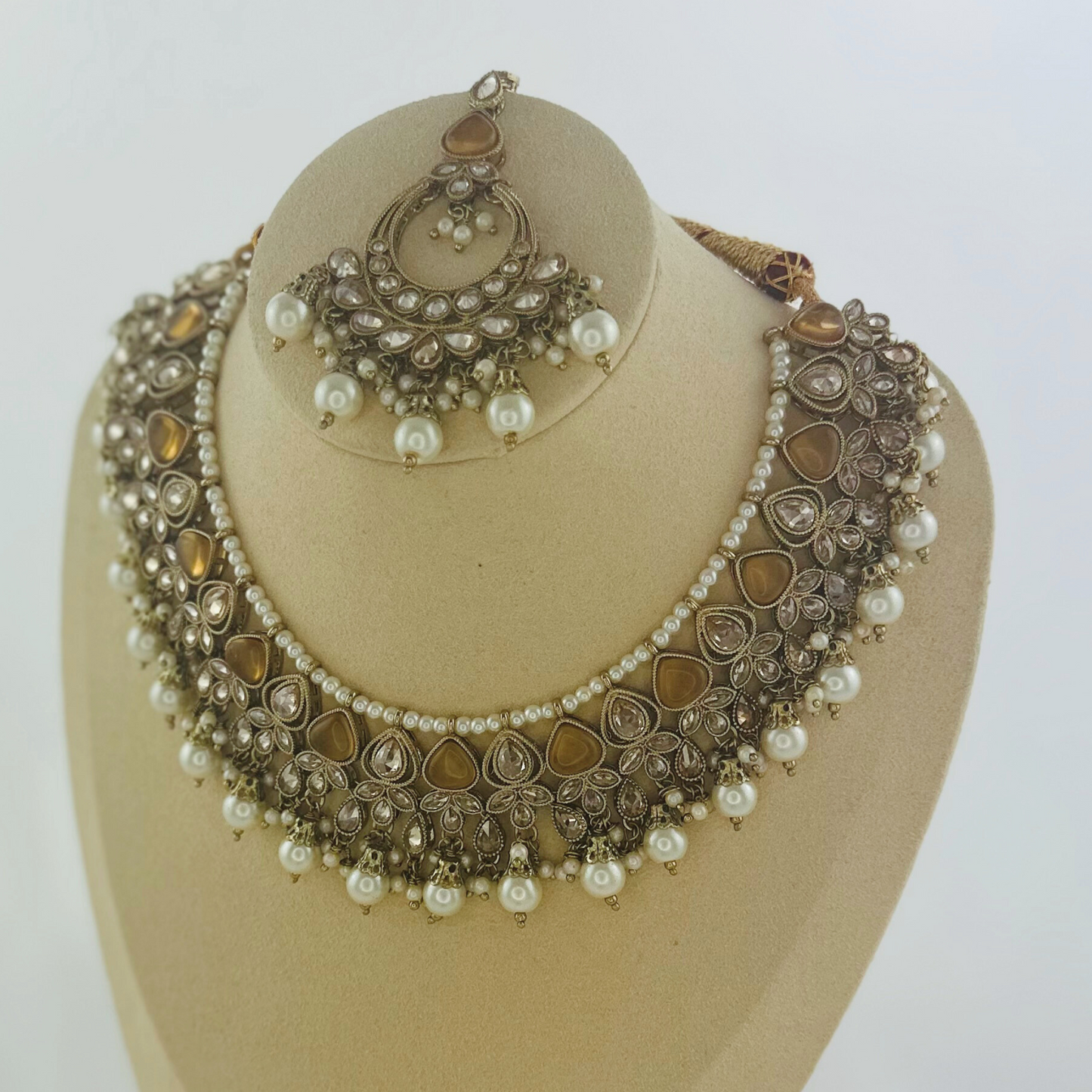 Necklace set with bronze stones and white pearl beads. Set includes necklace, tikka & earrings. Prefect for Indian weddings, parties and special occasions. Latest 2023 fashion. High end Indian fashion jewellery with top quality stones and beads.