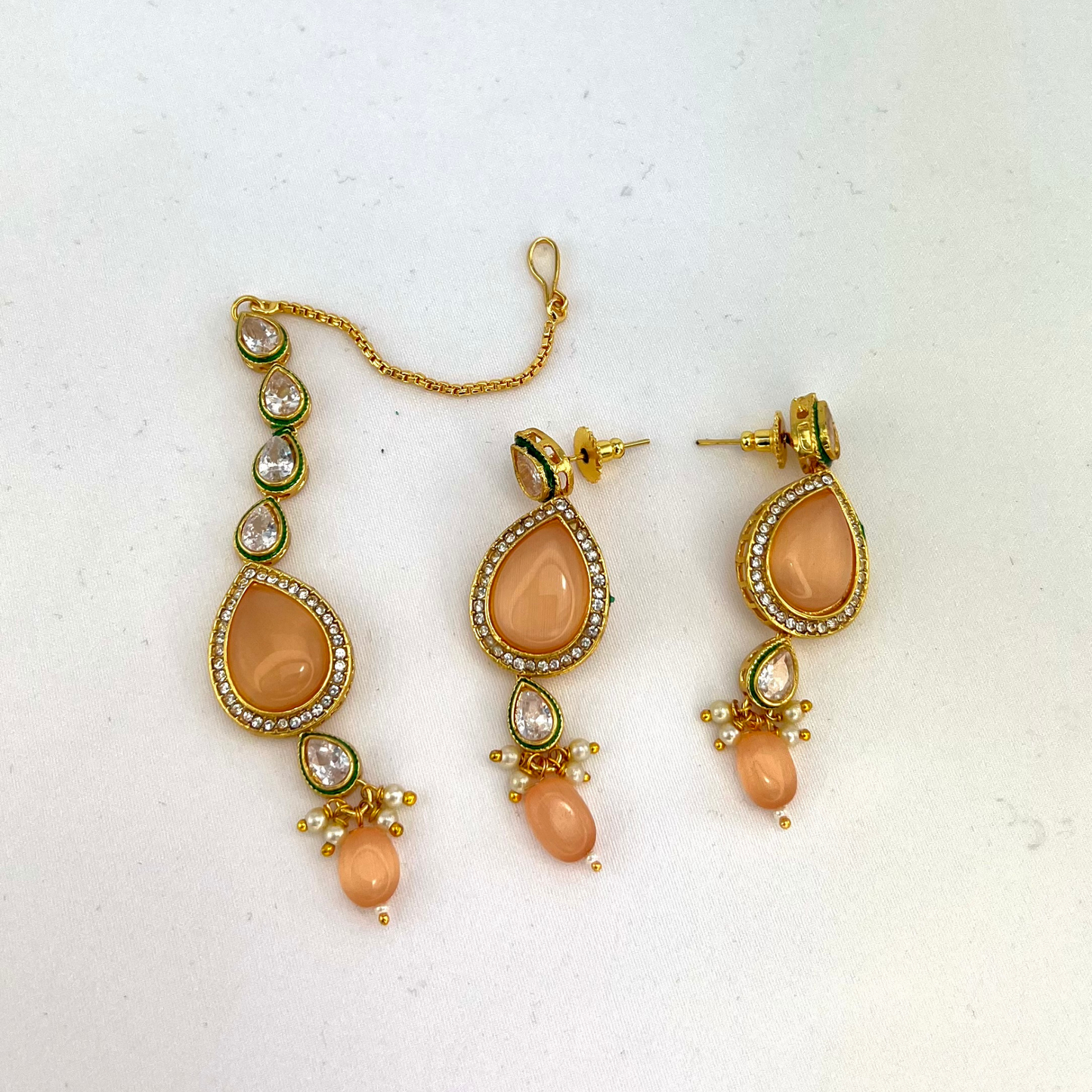 Choker set with peach, clear stones and peach beads. Set includes choker, tikka and earrings. Prefect for Indian weddings, parties and special occasions. Latest 2022 fashion. High end Indian fashion jewellery with top quality stones and beads.