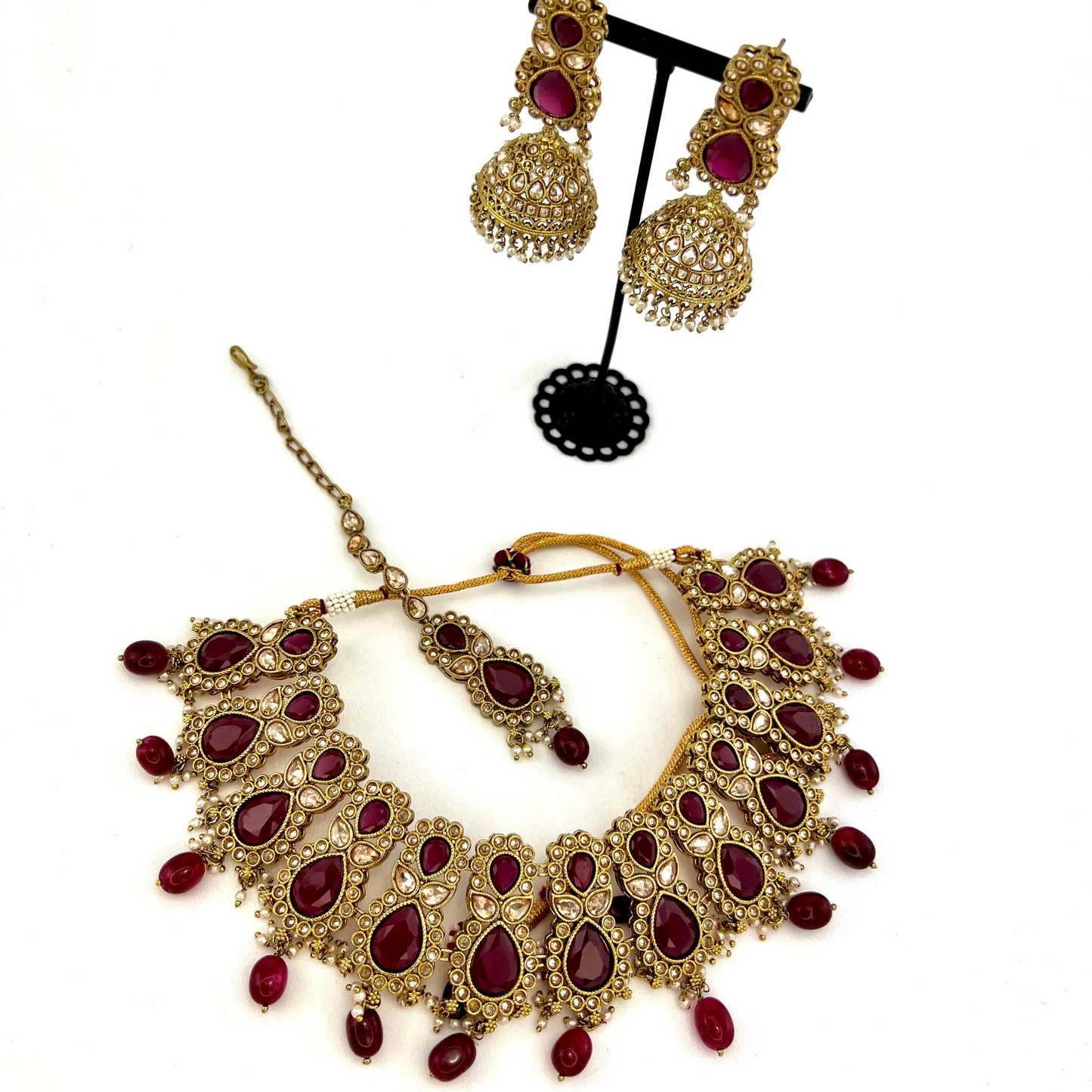 Necklace set with maroon and gold stone work and maroon beads.  Set includes necklace, tikka and earrings.  Prefect for Indian weddings, parties and special occasions.  Latest 2022 fashion. High end Indian fashion jewellery with top quality stones and beads.