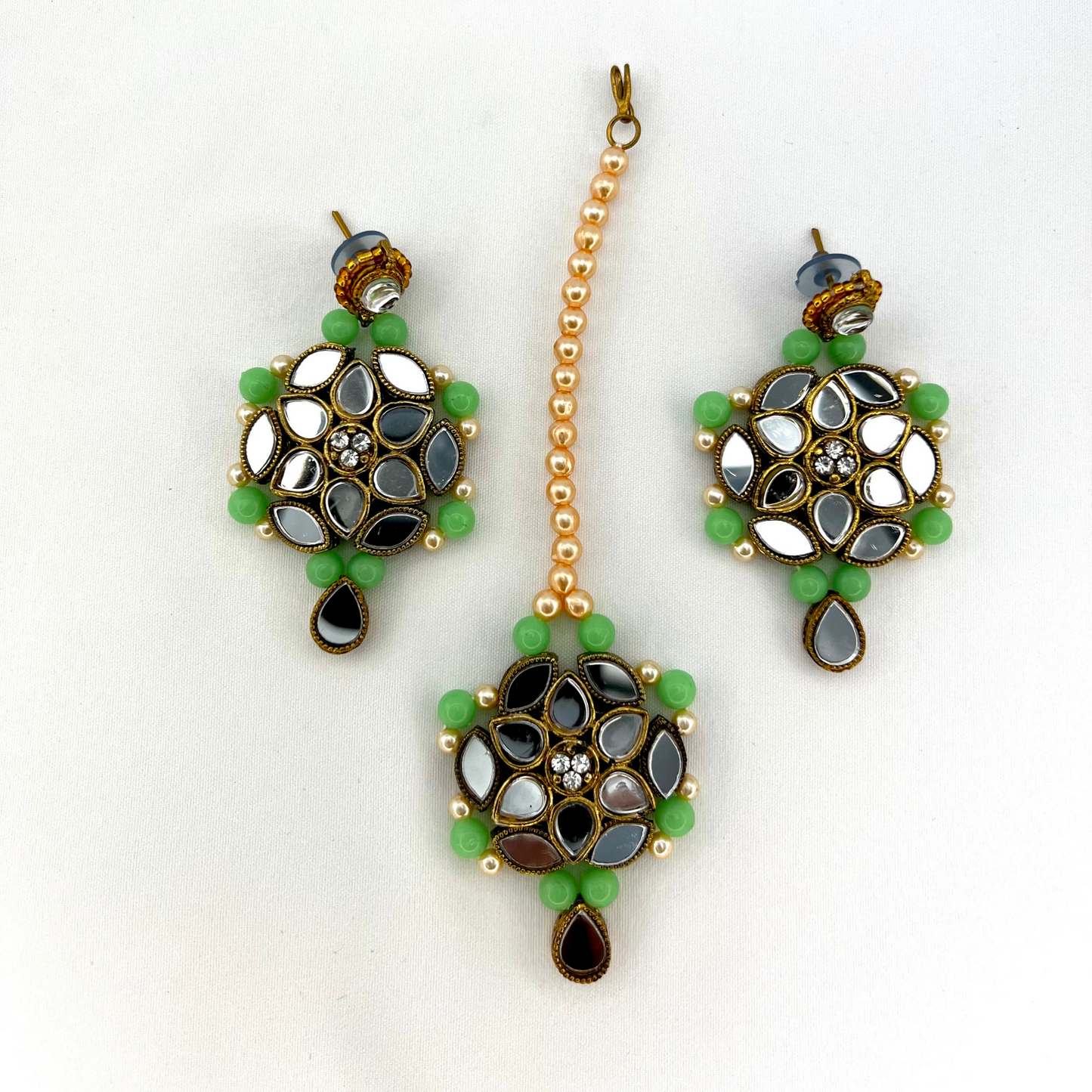 Mirror necklace set with green beads, clear stones and pearls. Set includes, necklace, tikka and earrings. Prefect for Indian weddings, parties and special occasions. Latest 2022 fashion. High end Indian fashion jewellery with top quality stones and beads.