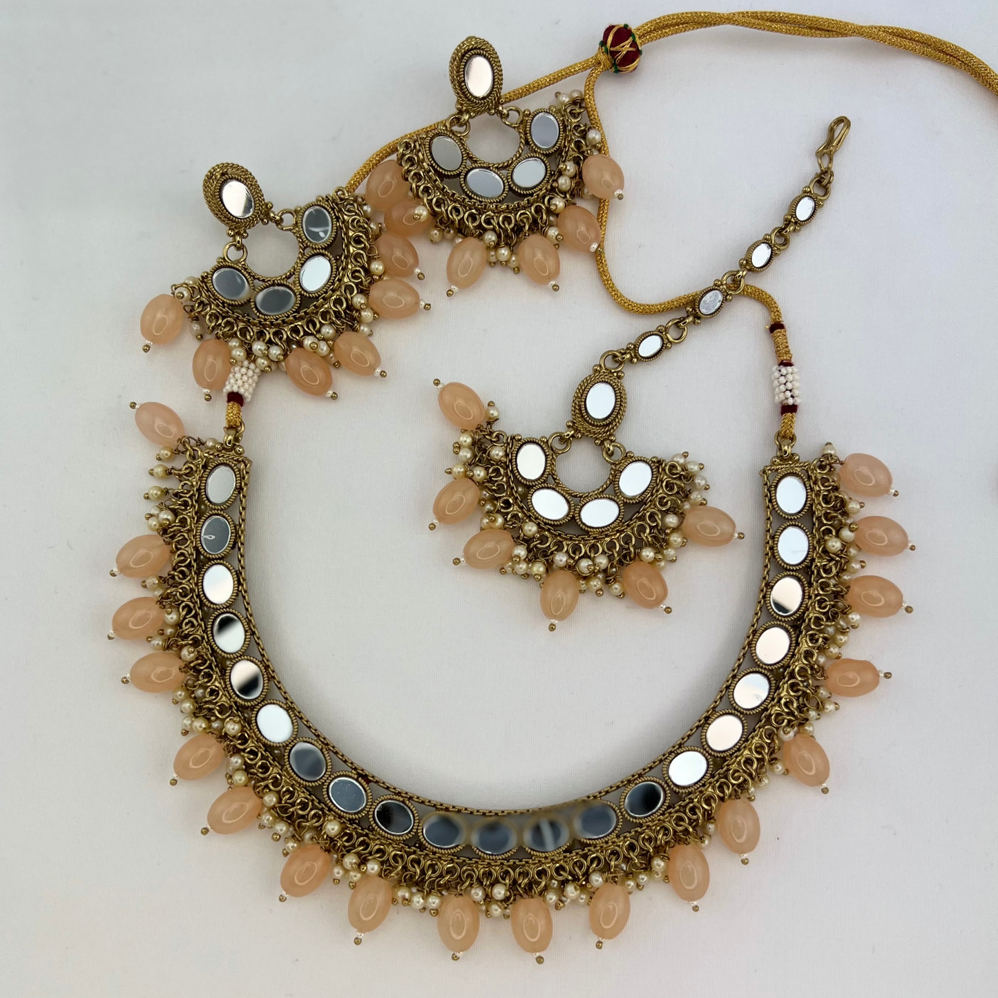Mirror necklace set with peach beads and small white pearls. Set includes necklace, tikka and earrings. Prefect for Indian parties, weddings and special occasions. Latest 2022 fashion.