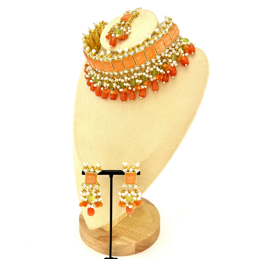 Choker set with with peach, clear stones and green, peach and orange beads,  Set includes choker, tikka and earrings.  Prefect for Indian weddings, parties and special occasions.  Latest 2022 fashion. High end Indian fashion jewellery with top quality stones and beads.