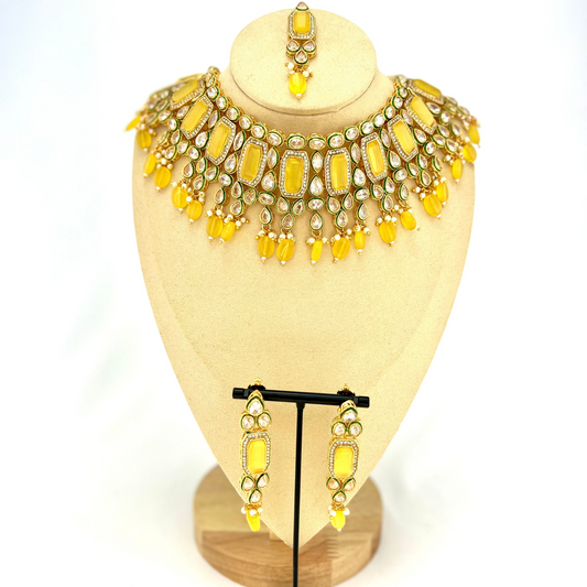 Necklace set with yellow beads and clear and yellow stones.  Set includes necklace, tikka and earrings.  Prefect for Indian weddings, parties and special occasions.  Latest 2022 fashion. High end Indian fashion jewellery with top quality stones and beads.