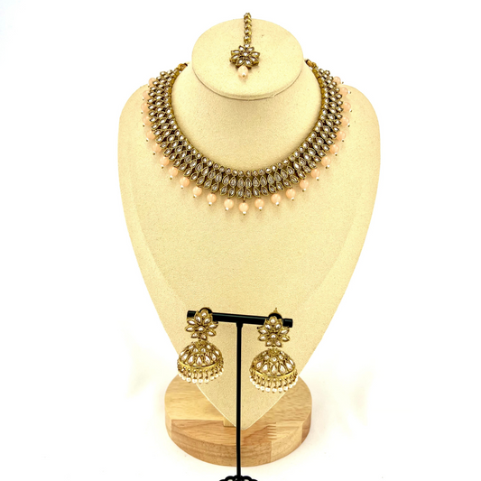 Necklace set with peach beads and gold stones.  Set includes necklace, tikka & earrings.  Prefect for Indian weddings, parties and special occasions.   Latest 2022 fashion. High end Indian fashion jewellery with top quality stones and beads.