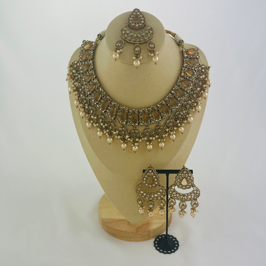 Necklace set with bronze stones and white pearl beads.  Set includes necklace, tikka & earrings.  Prefect for Indian weddings, parties and special occasions.   Latest 2023 fashion. High end Indian fashion jewellery with top quality stones and beads.