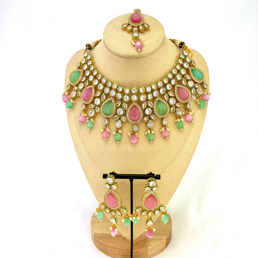 Necklace set with green, pink and clear stones and green and pink beads. Set includes necklace, tikka and earrings. Prefect for Indian weddings, parties and special occasions. Latest 2022 fashion. High end Indian fashion jewellery with top quality stones and beads.
