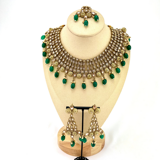 Necklace set with green beads and gold stone work.  Set includes necklace, tikka and earrings.  Prefect for Indian weddings, parties and special occasions.   Latest 2022 fashion. High end Indian fashion jewellery with top quality stones and beads.