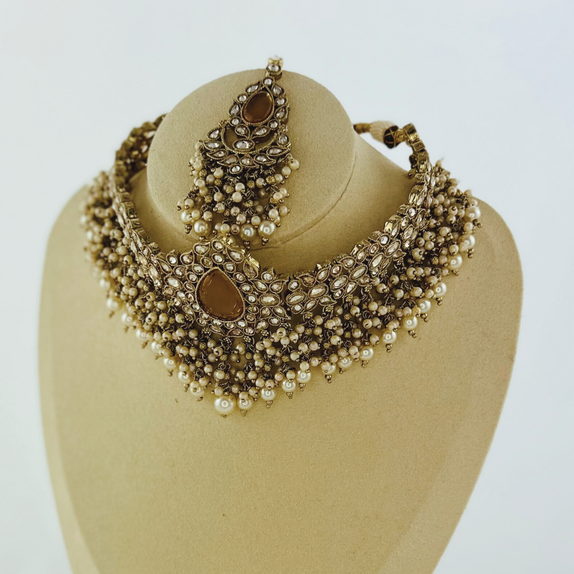 Choker set with bronze stones and white pearl beads.  Set includes necklace, tikka & earrings.  Prefect for Indian weddings, parties and special occasions.   Latest 2023 fashion. High end Indian fashion jewellery with top quality stones and beads.