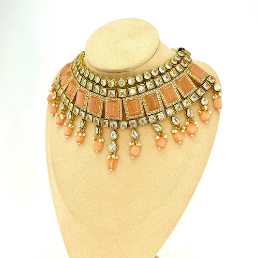 Necklace set with peach and clear stones and peach beads.  Set includes necklace, tikka and earrings.  Prefect for Indian weddings, parties and special occasions.  Latest 2022 fashion. High end Indian fashion jewellery with top quality stones and beads.