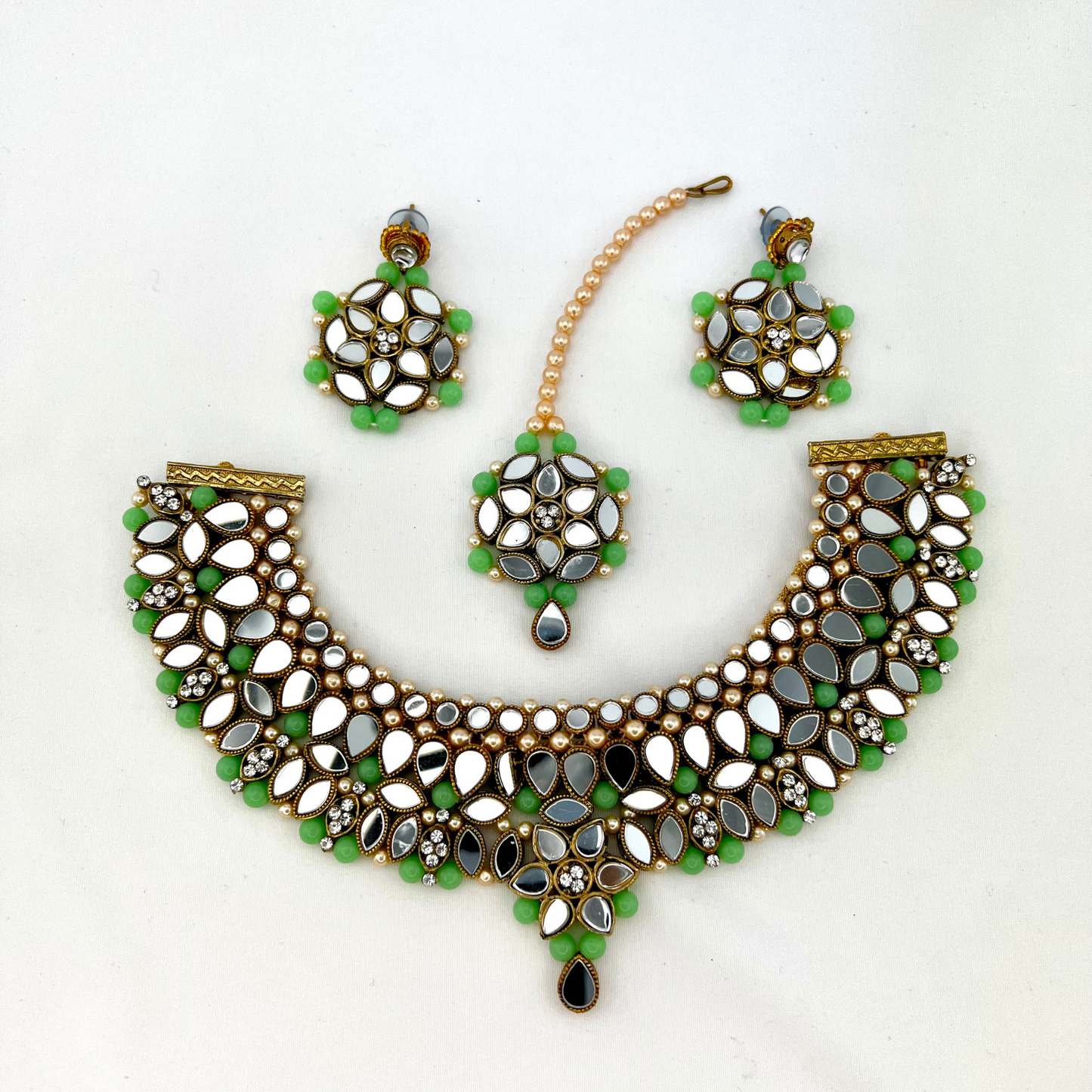Mirror necklace set with green beads, clear stones and pearls.  Set includes, necklace, tikka and earrings.  Prefect for Indian weddings, parties and special occasions.  Latest 2022 fashion. High end Indian fashion jewellery with top quality stones and beads.